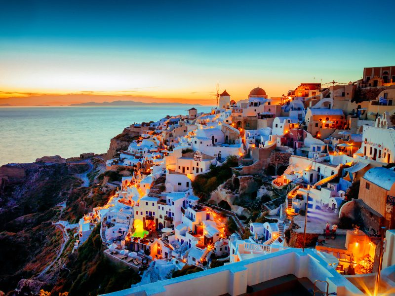 White houses and blue domes on the cliffs of Santorini above the Aegean Sea